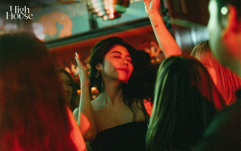 Young woman dancing and enjoying a stylish late-night hangout.