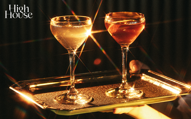 Two cocktail glasses on a tray at a bar